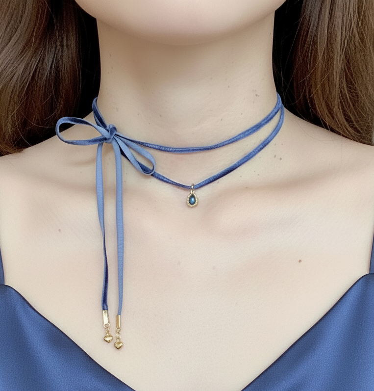 Blue ribbon choker necklace with a pendant on a person wearing a blue top.